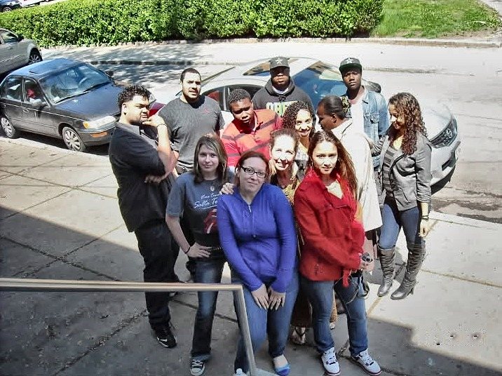 A class of the Excel High School Diploma Program standing together in front of the school